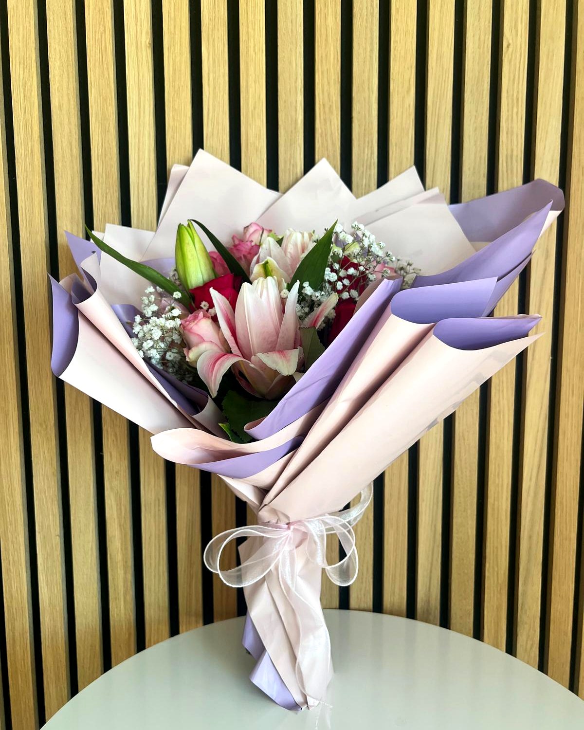 Blumenstrauss mit Lilien und Rosen in rosa und lila Papier mit Schleife – TIKIS