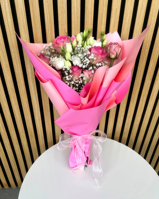 Blumenstrauss mit rosa Rosen, weissem Lisianthus und Schleierkraut in rosa Verpackung – TIKIS